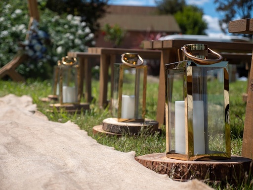 Medium Gold Lanterns with LED Pillar Candles on Wooden Slices